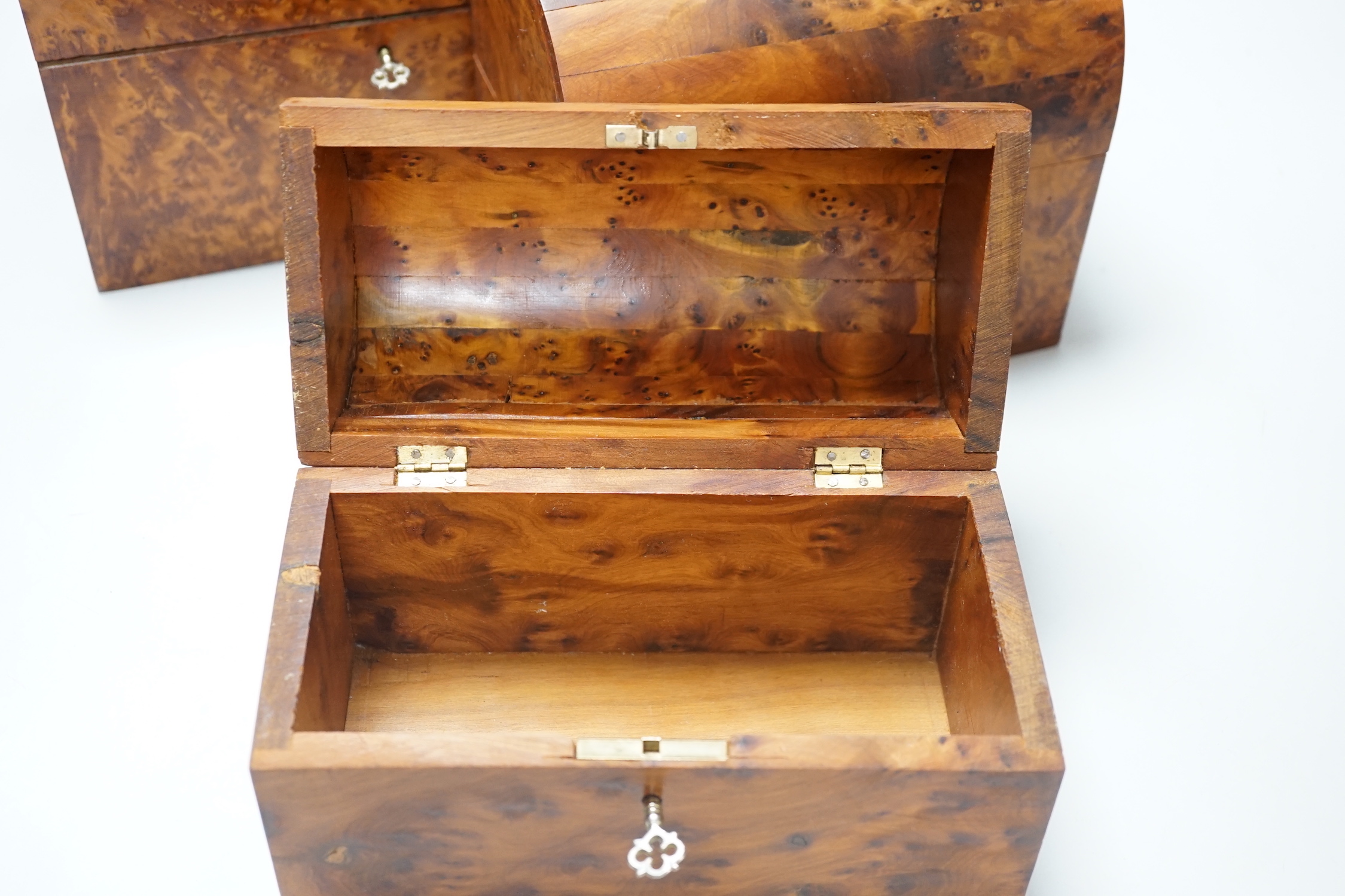 Three yewwood graduated dome topped caskets, largest 20cm high